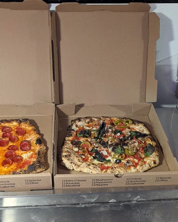 Two Jimbo Slice pizzas boxed and ready